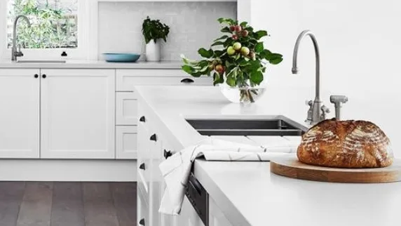 All white galley kitchen with dark timber flooring and concrete benchtops