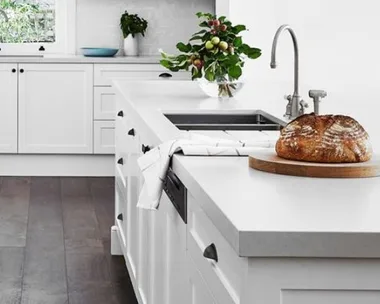 All white galley kitchen with dark timber flooring and concrete benchtops