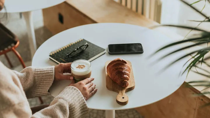 frothed milk in coffee with pastries on table
