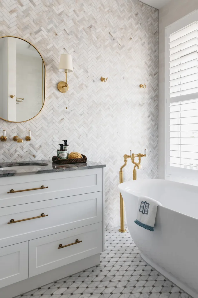 A bathroom with a freestanding bath and wall tiling.