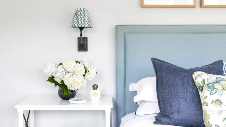 Blue and white contemporary coastal bedroom with side table and soft bedhead.
