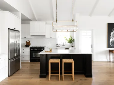 A white and black Hamptons style kitchen with raised ceilings.