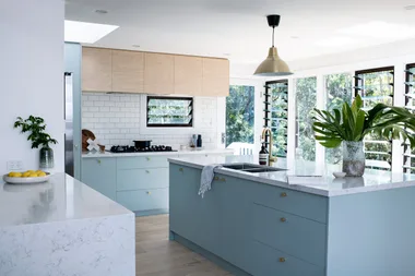white subway tiled splashback with light blue cabinetry