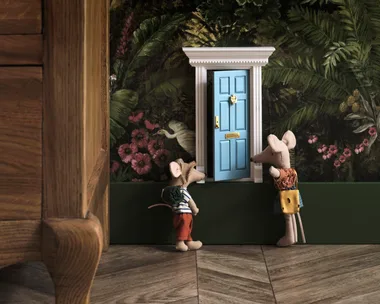Toy mice in front of a miniature blue door.