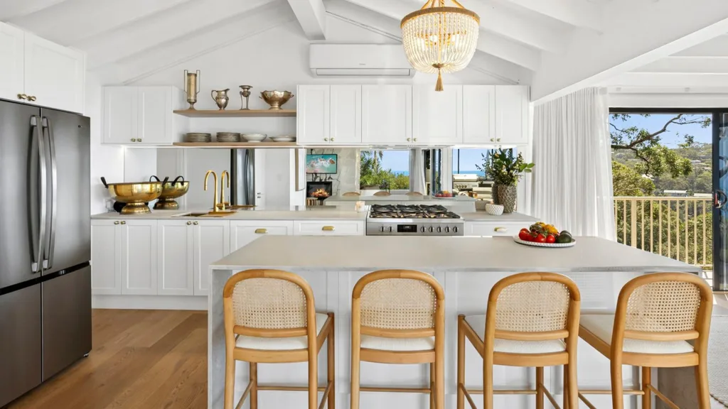 Mitch and mark from the block's newport house sale featuring 
a white hamptons kitchen, timber barstools, raked ceiling and a mirrored splashback