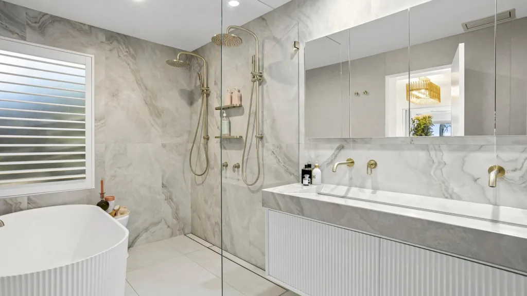 Mitch and mark from the block's newport house is for sale, featuring a white marble ensuite bathroom and freestanding bath. plus a double shower
