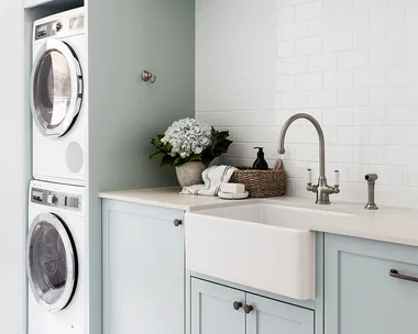 Pale blue laundry hanging rail stacked washer dryer