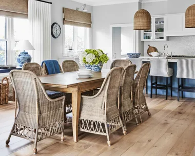The dining room in a Bowral cottage with woven chairs, blinds and pendant.